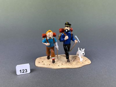 a figurine of two people and a dog on a table