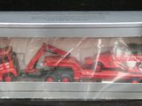 un camion rouge en jouet et un camion rouge dans une boîte