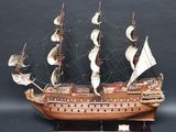 une maquette en bois d'un grand voilier posée sur un socle