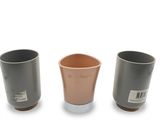 trois tasses posées les unes à côté des autres sur une surface blanche