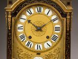 a gold clock with black and white roman numerals on it