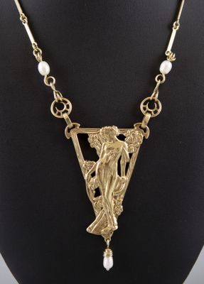 un collier plaqué or représentant une femme tenant une perle