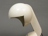 a white table lamp with a black cord on top of it