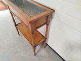 a wooden table with a glass top and a shelf