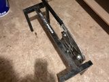 a clamp that is sitting on the floor in front of a shelf