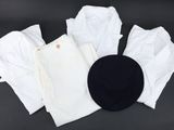un chapeau noir posé au sommet d'une pile de vêtements blancs