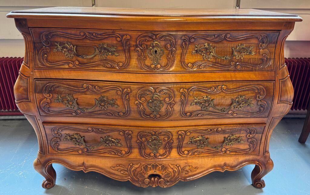 Commode en bois naturel galbée toute face de style Régence. Larg : 125 cm.