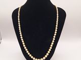 un collier de perles blanches sur un mannequin noir
