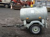 a trailer with a tank attached to it in a parking lot