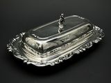 un plat ancien en argent recouvert d'un couvercle en verre sur fond noir