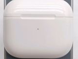 des AirPods blancs posés sur une surface grise