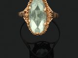 a gold ring with an oval aquamarinee stone surrounded by filigree filigree