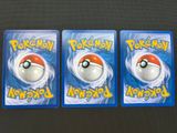 three pokemon cards are sitting on top of a table