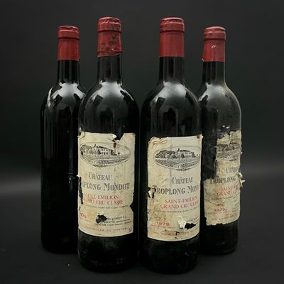 trois bouteilles de vin rouge sont alignées sur une surface noire