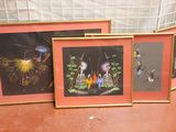 three framed pictures of people and animals are on a table