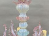 a glass chandelier with pink and blue decorations on it