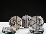 three plates with designs on them sit on a white surface