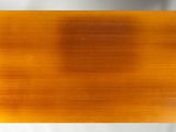 a close up of a piece of orange glass on a white surface