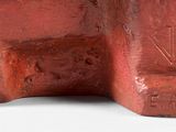 a red sculpture of a man and a woman sitting on top of each other