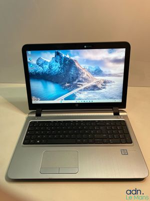 un ordinateur portable ouvert posé sur une table blanche
