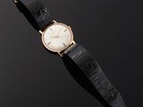 a close up of a watch on a black surface