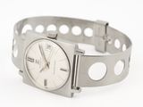 a close up of a watch on a bracelet on a white surface