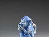 deux petites figurines bleues et blanches représentant des singes assis l'un à côté de l'autre