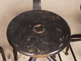 three black stools sitting next to each other on the floor