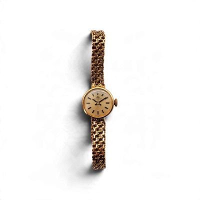 un gros plan d'une montre sur une surface blanche avec un fond blanc