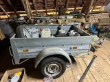 a small trailer with a trailer bed in a garage