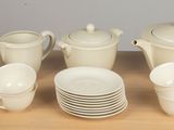 a lot of white dishes and cups on the table