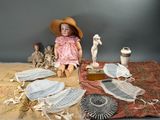 une poupée assise sur un tapis, entourée d'autres objets
