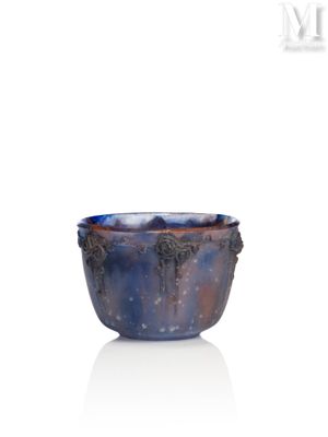 un bol bleu et violet posé sur une surface blanche