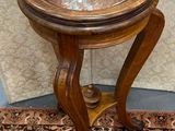 a small wooden table with a glass top on a rug