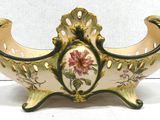 a vase that has a flower on it on a stand