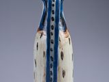 a small blue and white vase with spots on it
