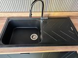 a black kitchen sink with a black faucet and a black faucet