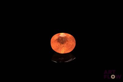 an orange moon in the dark sky with a reflection on the ground