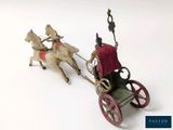 a figurine of a man riding in a carriage pulled by a horse
