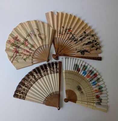 quatre éventails en bois ornés de motifs floraux sur fond blanc