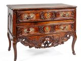 une vieille commode en bois ornée de sculptures élaborées sur le dessus