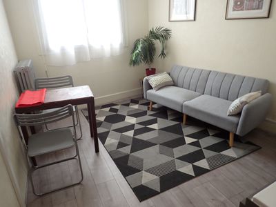 un salon avec un canapé, un fauteuil, une table et un tapis