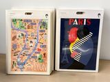 three books on a table with a map of paris and a map of london
