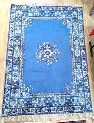 rug on the floor of a living room with a chair and a table