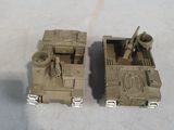 two toy army vehicles that are sitting on a table