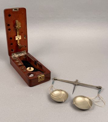 a wooden case with a pair of bells and a pair of measuring spoons