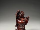 a small chinese carved wood figure of a laughing man