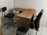 un bureau avec une chaise et une poubelle dans un coin