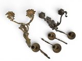 trois bougeoirs en laiton ancien et un porte-bougie sur fond blanc
