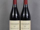 deux bouteilles de vin rouge sont posées l'une à côté de l'autre sur une table
